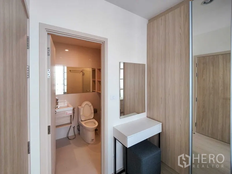 Condominium for rent - Bedroom entrance to ensuite bathroom with toilet, vanity and open storage shelves.
