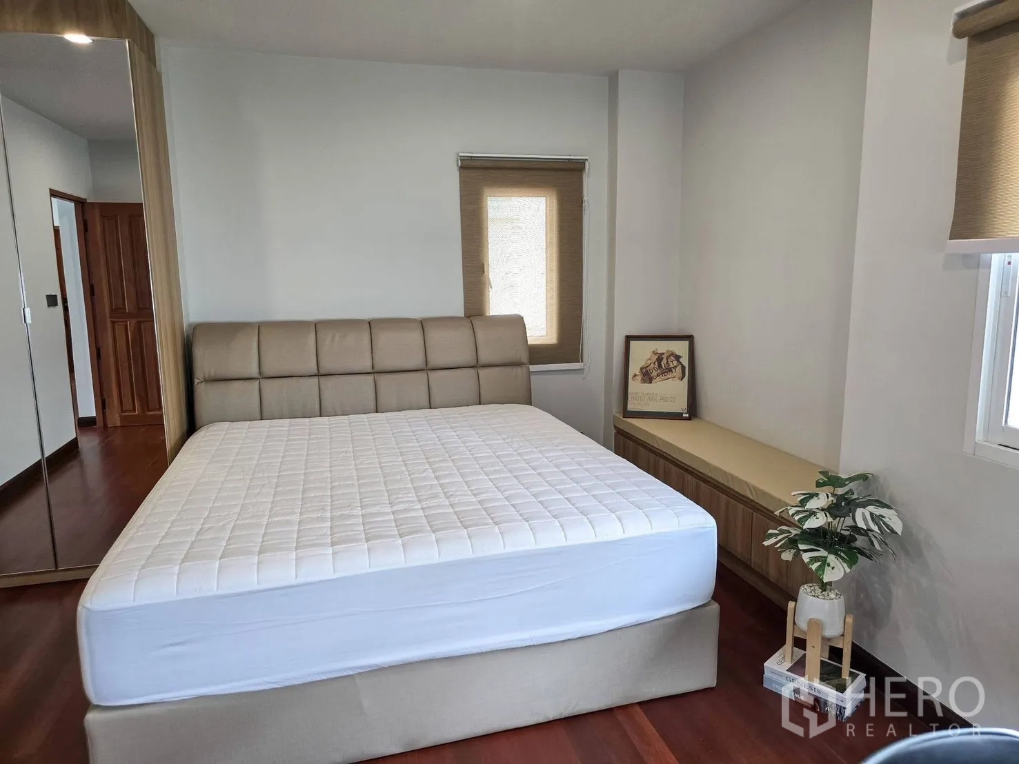 Detached House for rent in Suan Luang, Bangkok - Bright bedroom with upholstered bed, wood floors and bench by the window.