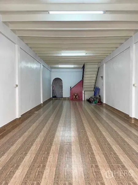 店屋 出售在Phra Khanong, Bangkok - 一层开放式空间，条纹瓷砖地面，白色梁顶，后部设有楼梯。