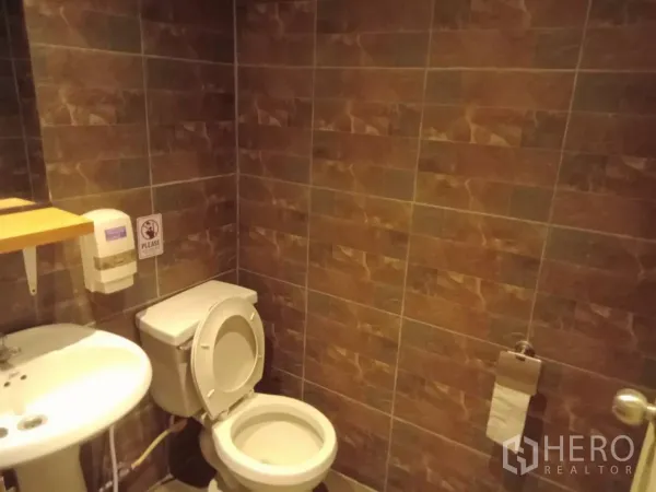 独立式住宅 出租在Phaya Thai, Bangkok - 棕色墙砖卫浴，配洗手盆与坐便器。