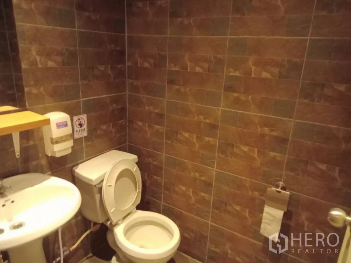 独立式住宅 出租在Phaya Thai, Bangkok - 棕色墙砖卫浴，配洗手盆与坐便器。