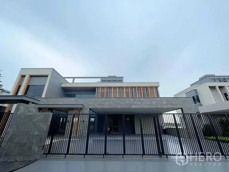 Detached House for sale in Bang Phli, Samut Prakan - Modern detached house exterior with a gated frontage and stone-and-wood accents.
