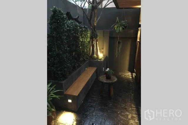บ้าน ให้เช่าในWatthana, Bangkok - ลานกลางบ้านมีแปลงต้นไม้ ม้านั่ง และไฟส่องสว่างยามค่ำ