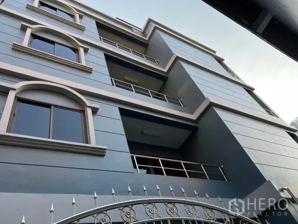 带办公室的家 出租在Pathum Wan, Bangkok - 帕吞旺现代多层家庭办公楼外立面，拱形窗与阳台清晰可见。