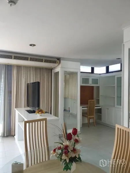 Condominium for rent in Watthana, Bangkok - Dining and TV area with floor-to-ceiling curtains and a built-in study nook.