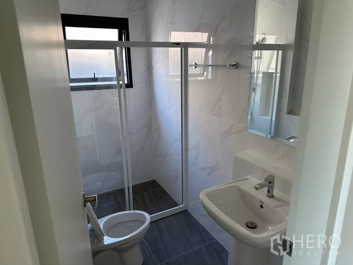 Detached House for rent in Bang Phli, Samut Prakan - Second bathroom with shower cabin, window and white vanity.