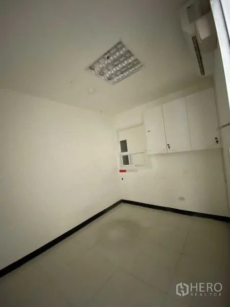 零售空间 出租 - 后勤办公室，小窗与白色壁柜、瓷砖地面。