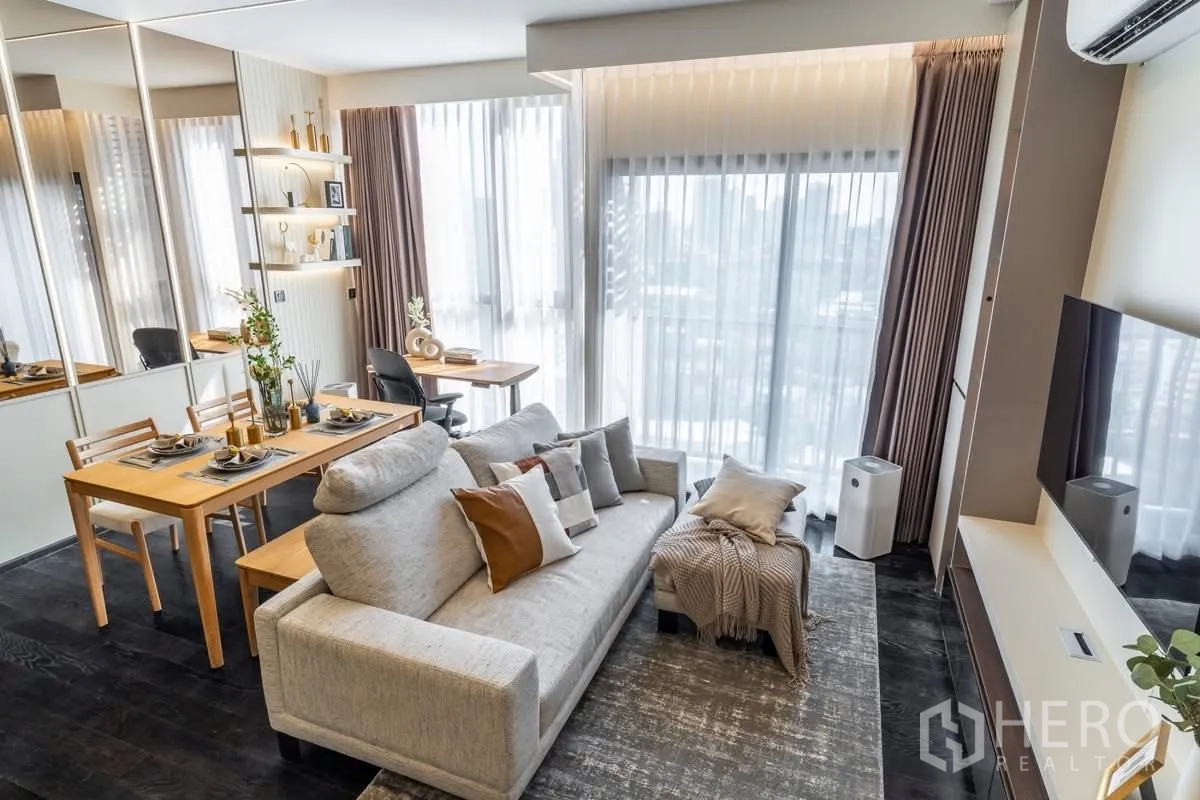 คอนโด for rent or sale in Watthana, Bangkok - พื้นที่นั่งเล่นแบบโอเพ่นพร้อมโซฟา โต๊ะอาหาร โต๊ะทำงาน หน้าต่างเต็มบาน และทีวีติดผนัง