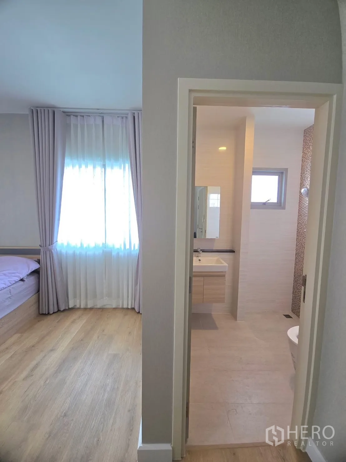 Detached House for rent in Lat Krabang, Bangkok - View from hallway into a bathroom and light-filled bedroom.