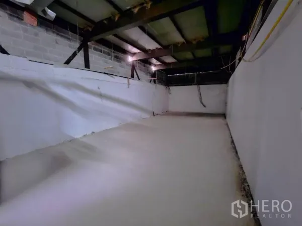 Warehouse for rent in Chatuchak, Bangkok - Long mezzanine storage area with white walls and steel roof structure.