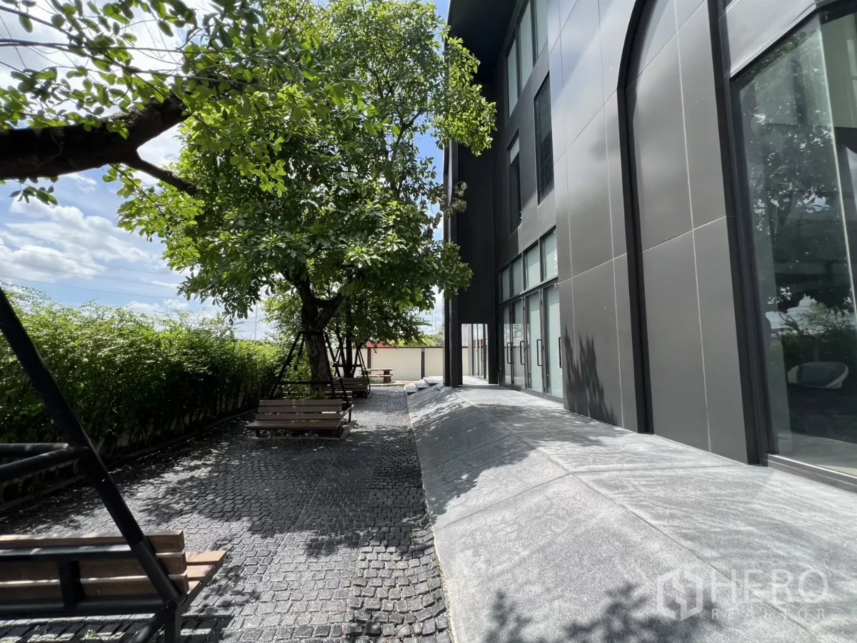 คลังสินค้า ขายในLat Krabang, Bangkok - ทางเดินร่มรื่นมีม้านั่งและแนวพุ่มไม้ข้างอาคาร.