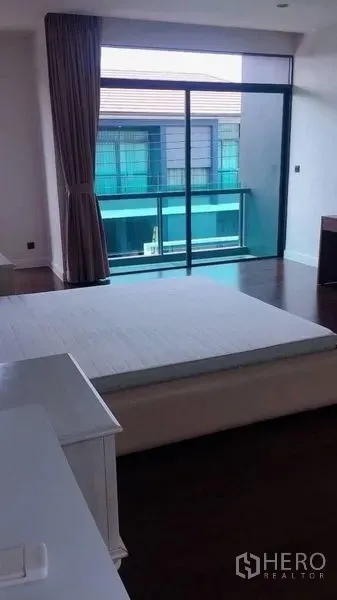 Detached House for rent in Bang Kapi, Bangkok - Bedroom opening to a balcony through full-height sliding glass doors.