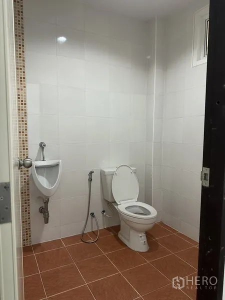 Factory for rent in Bang Bo, Samut Prakan - Clean tiled restroom with toilet, urinal and handheld bidet.
