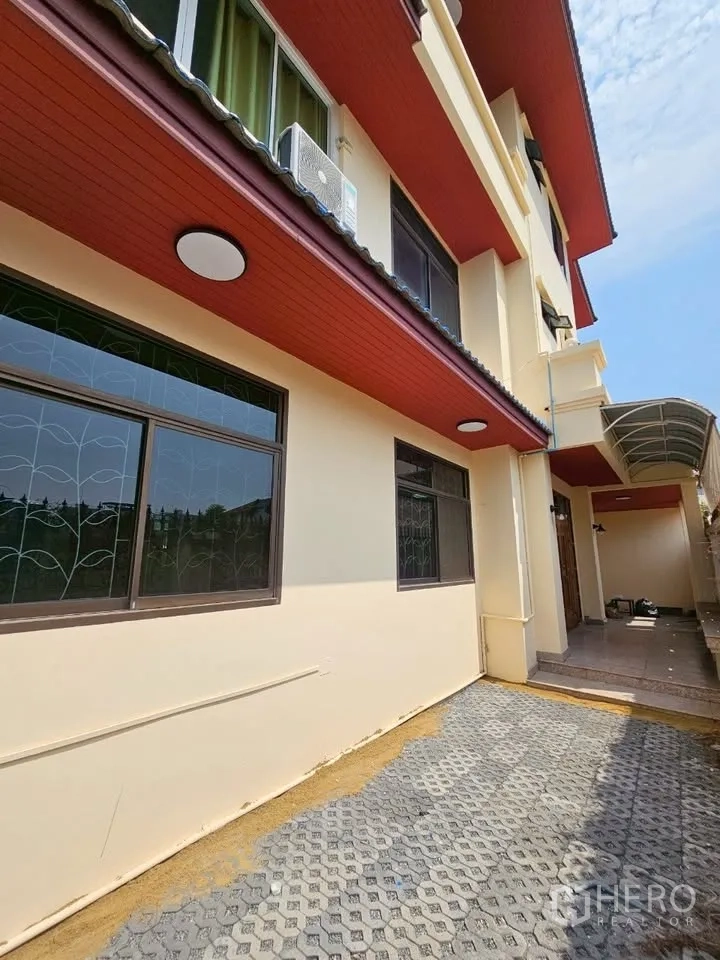 สำนักงานที่บ้าน for rent in Wang Thonglang, Bangkok - ด้านนอกอาคารสีครีม ชายคาสีแดง หน้าต่างเหล็กดัด และลานปูพื้น