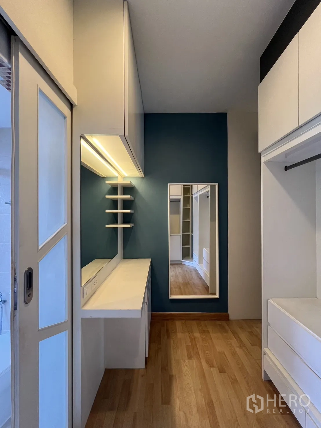 Townhouse for rent in Wang Thonglang, Bangkok - Vanity room with mirror, blue accent wall and storage.