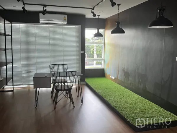 Detached House for rent or sale in Don Mueang, Bangkok - Corner workspace with window blinds, black pendant lights and raised green turf platform.
