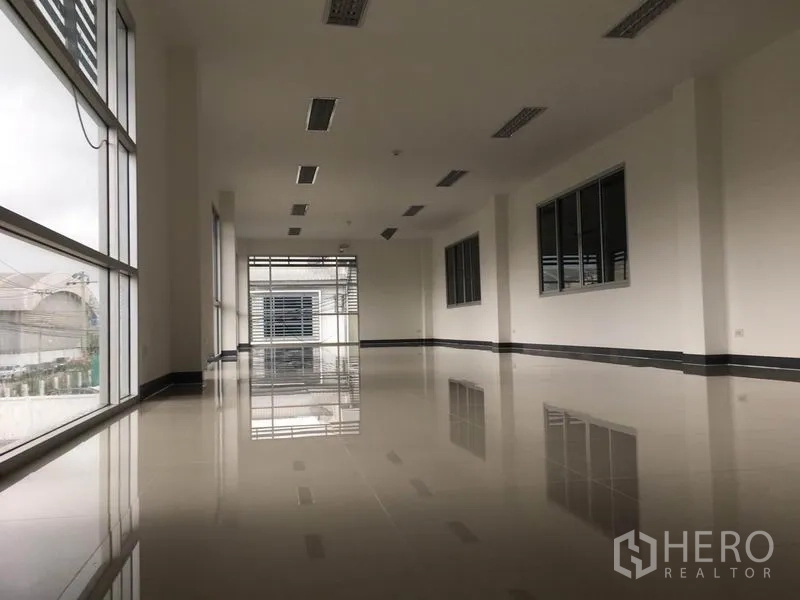 工厂 出租在Samut Prakan - 二楼办公区，落地窗、亮面地坪与荧光灯照明。