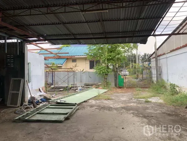 คลังสินค้า ให้เช่าในSai Mai, Bangkok - พื้นที่โหลดสินค้ามุงหลังคาพร้อมลานกว้างในรั้ว โครงประตูเลื่อนวางบนพื้น