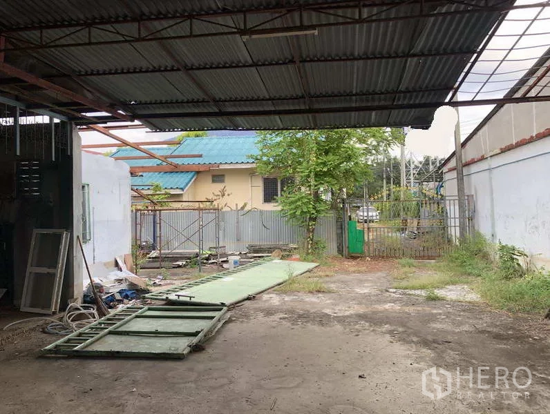 คลังสินค้า ให้เช่าในSai Mai, Bangkok - พื้นที่โหลดสินค้ามุงหลังคาพร้อมลานกว้างในรั้ว โครงประตูเลื่อนวางบนพื้น