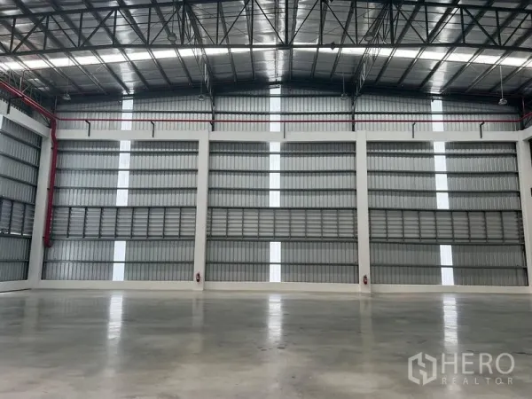 Factory for rent in Bang Pakong, Chachoengsao - Expansive industrial hall with steel truss roof, daylight strips and smooth concrete flooring.