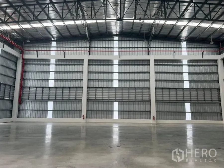 Factory for rent in Bang Pakong, Chachoengsao - Expansive industrial hall with steel truss roof, daylight strips and smooth concrete flooring.