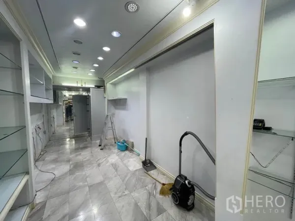 店屋 出租在Bang Rak, Bangkok - 走道铺大理石地砖，展示墙与清洁设备可见。