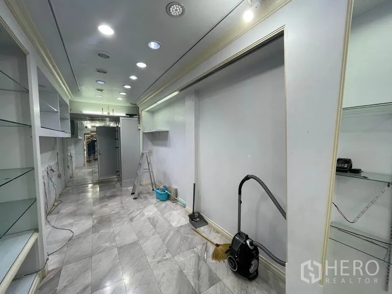 店屋 出租在Bang Rak, Bangkok - 走道铺大理石地砖，展示墙与清洁设备可见。