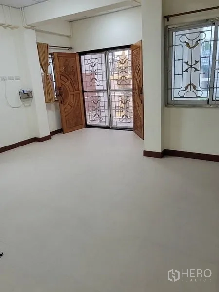 บ้าน ให้เช่าในKhlong Toei, Bangkok - ห้องชั้นล่างมีประตูไม้บานคู่และประตูกันขโมย พื้นกระเบื้องสะอาด