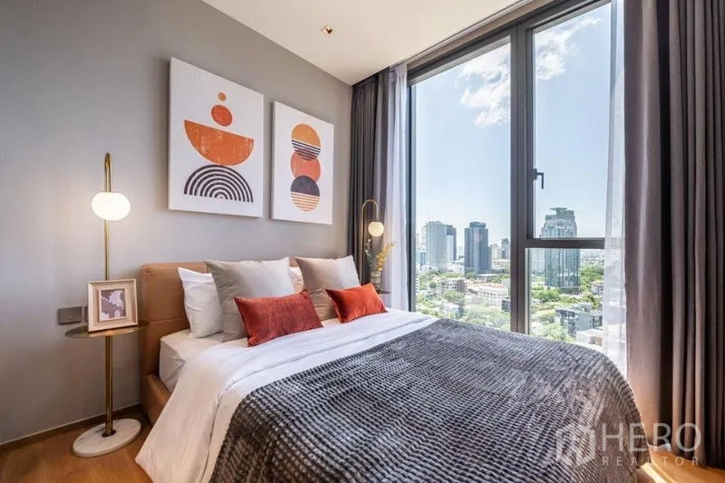 Condominium for rent in Khlong Toei, Bangkok - Secondary bedroom with large windows, modern artwork and sweeping city views.
