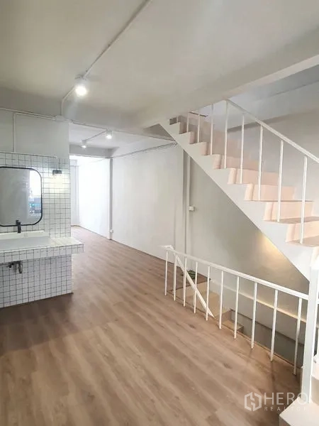 อาคารพาณิชย์ ให้เช่าในPhra Khanong, Bangkok - พื้นที่ทำงานโล่ง มีบันไดและซิงค์กรุกระเบื้องบนผนังสีขาว พื้นไม้