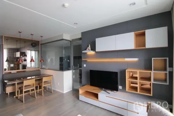 Condominium for rent in Bang Sue, Bangkok - Open-plan lounge facing the dining nook and glass-partitioned kitchen with contemporary media cabinetry.