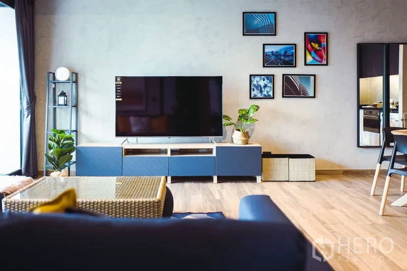 คอนโด ให้เช่าหรือขายในWatthana, Bangkok - ผนังทีวีพร้อมชั้นวางสื่อ ไม้กระถาง และกรอบรูปในห้องนั่งเล่น