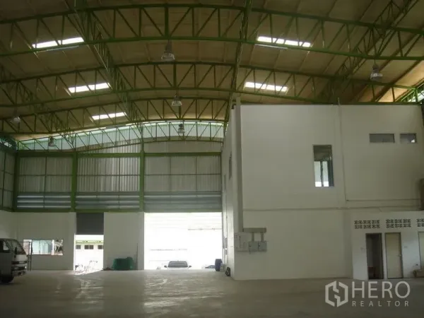 คลังสินค้า ให้เช่าในLat Krabang, Bangkok - ภายในโกดังเพดานสูง โครงเหล็กสีเขียว มีช่องแสงหลังคา ทางเข้าประตูม้วนขนาดใหญ่ และออฟฟิศภายใน