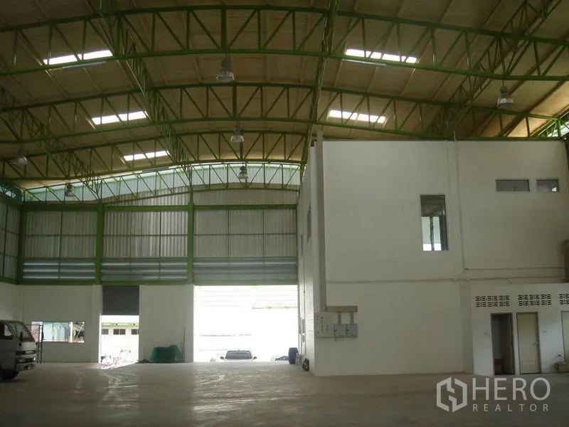คลังสินค้า ให้เช่าในLat Krabang, Bangkok - ภายในโกดังเพดานสูง โครงเหล็กสีเขียว มีช่องแสงหลังคา ทางเข้าประตูม้วนขนาดใหญ่ และออฟฟิศภายใน