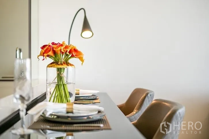 คอนโด ให้เช่าในBang Rak, Bangkok - เคาน์เตอร์ทานอาหารพร้อมเก้าอี้สองตัวและโคมไฟอ่านหนังสือ