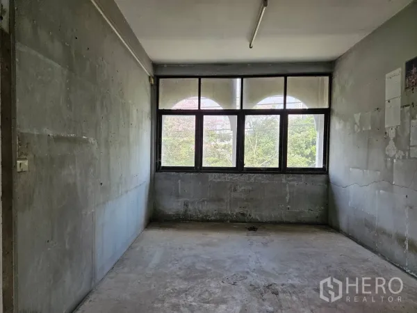 店屋 出租在Watthana, Bangkok - 楼上房间，混凝土墙面与大窗，眺望绿树景观。