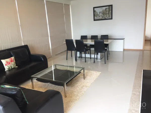 公寓 出租在Sathon, Bangkok - 一体化客餐厅，黑色皮沙发、玻璃茶几与六人餐桌。