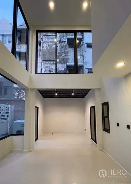 สำนักงานที่บ้าน ขายในLat Phrao, Bangkok - ห้องรับแขกเพดานสูงสองชั้นพร้อมกระจกเต็มบานและชั้นลอย