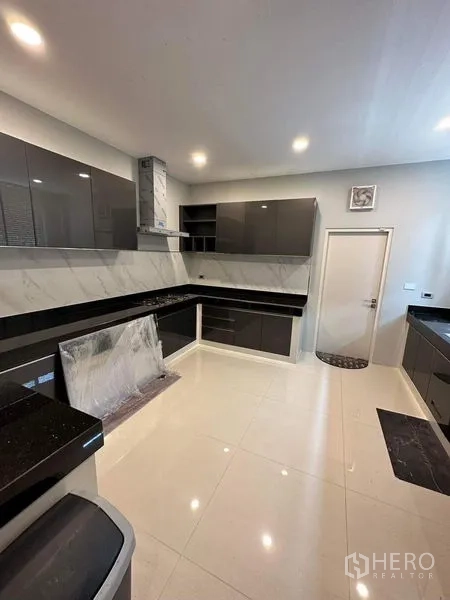 Detached House for sale - Secondary Thai kitchen with glossy cabinets and marble backsplash.