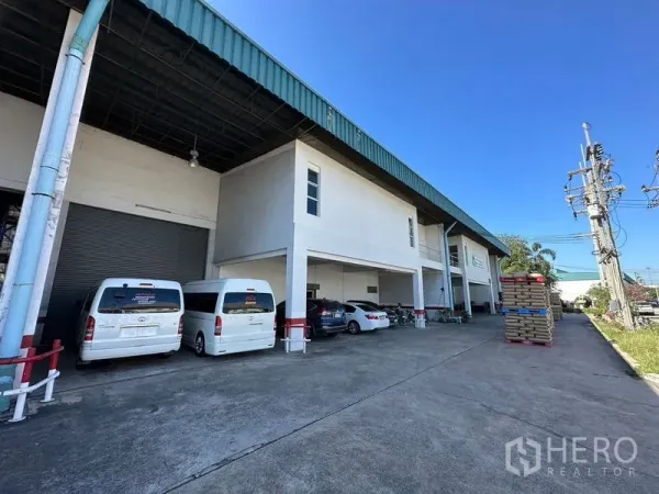 工厂 出租在Si Racha, Chon Buri - 是拉差工厂外观，带遮雨装卸区、卷帘门及宽阔停车场。