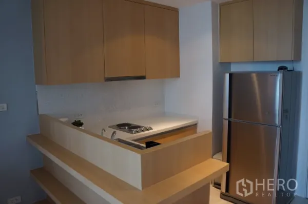 คอนโด ให้เช่าในRatchathewi, Bangkok - ครัวบิวท์อินโทนไม้ เตาไฟฟ้า และตู้เย็นสเตนเลส