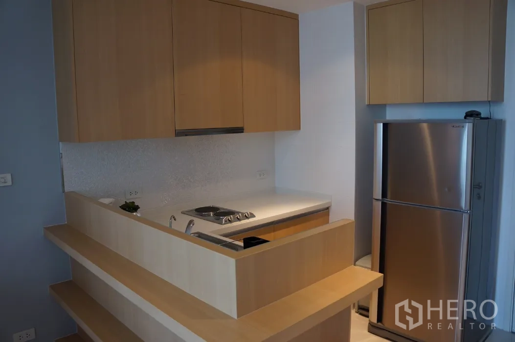 คอนโด ให้เช่าในRatchathewi, Bangkok - ครัวบิวท์อินโทนไม้ เตาไฟฟ้า และตู้เย็นสเตนเลส