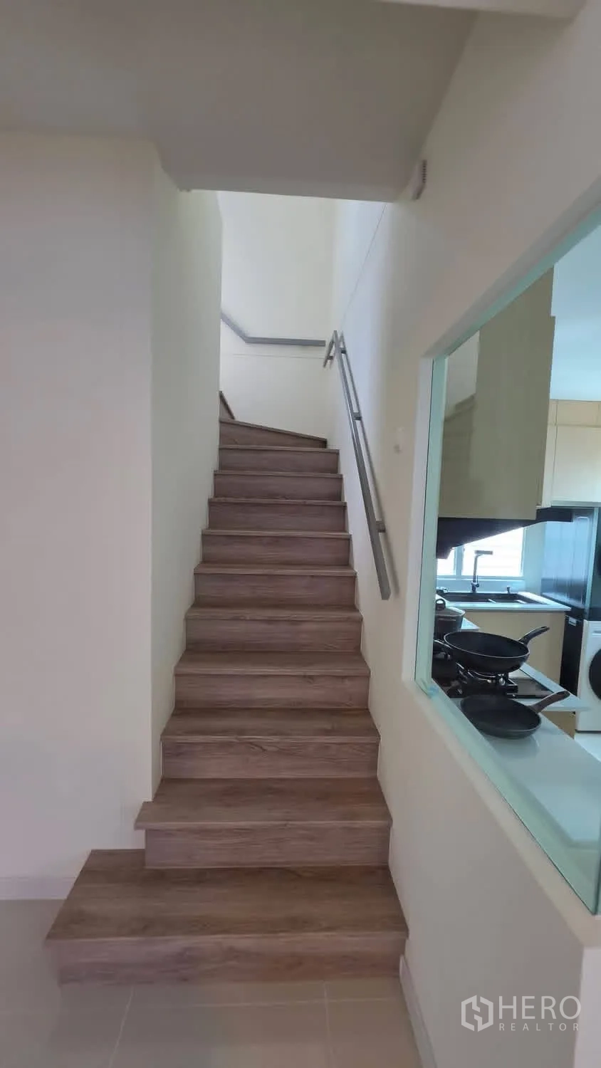 Detached House for rent in Bang Phli, Samut Prakan - Wood staircase with handrail beside the kitchen.
