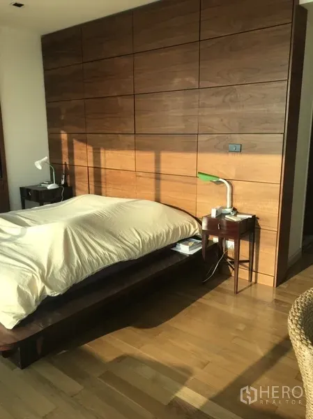 คอนโด ให้เช่าหรือขายในKhlong San, Bangkok - ห้องนอนหลักบรรยากาศอบอุ่น ผนังไม้ตกแต่ง และเตียงแบบยกพื้น