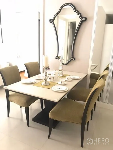 คอนโด ให้เช่าในPathum Wan, Bangkok - มุมรับประทานอาหาร โต๊ะสี่ที่นั่งพร้อมจานช้อนส้อมและเชิงเทียน ตกแต่งด้วยกระจกแขวนผนัง
