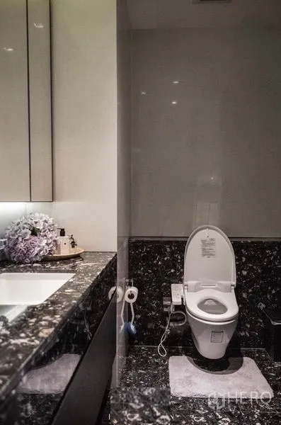 公寓 出租在Khlong Toei, Bangkok - 现代卫浴，黑色大理石台盆柜与坐便器。