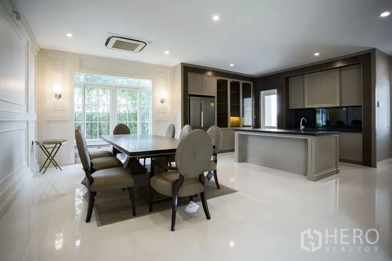 独立式住宅 出租在Mueang Samut Prakan, Samut Prakan - 开放式餐厅与现代岛台厨房，柜体齐全大窗通透。