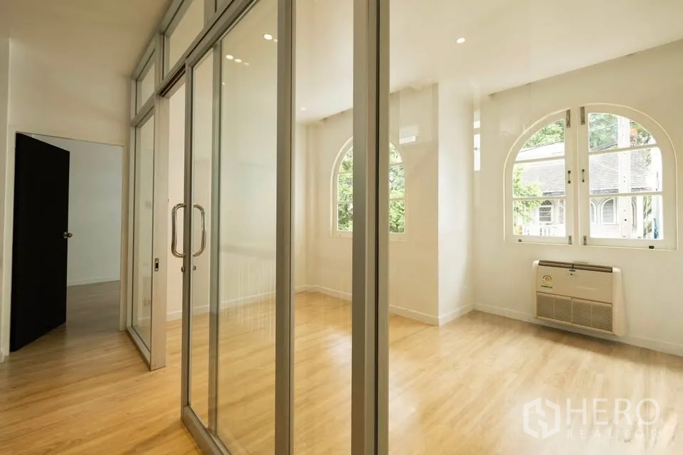 联排别墅 出租在Khlong Toei, Bangkok - 走廊采用整面落地玻璃推拉隔断，拱形窗使空间通透明亮。