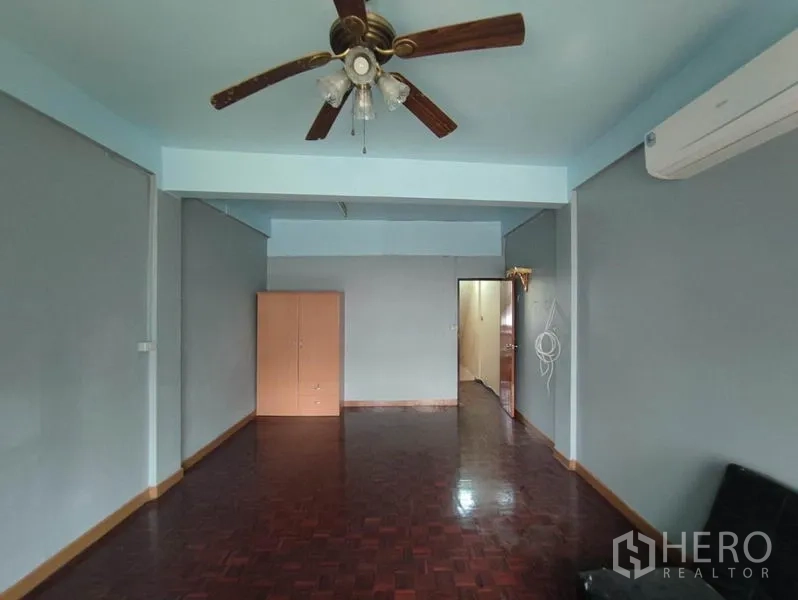 Shophouse for rent in Khlong Toei, Bangkok - Spacious room with ceiling fan, air conditioning and polished parquet floor.