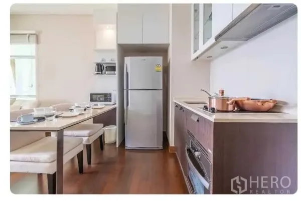 公寓 出售在Watthana, Bangkok - 走廊式现代厨房，内置烤箱、灶台与储物柜